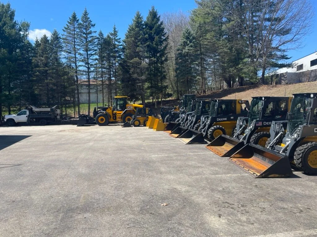 Outdoor hardscaping and landscaping tools and materials staged in a work environment, representing the range of services offered.